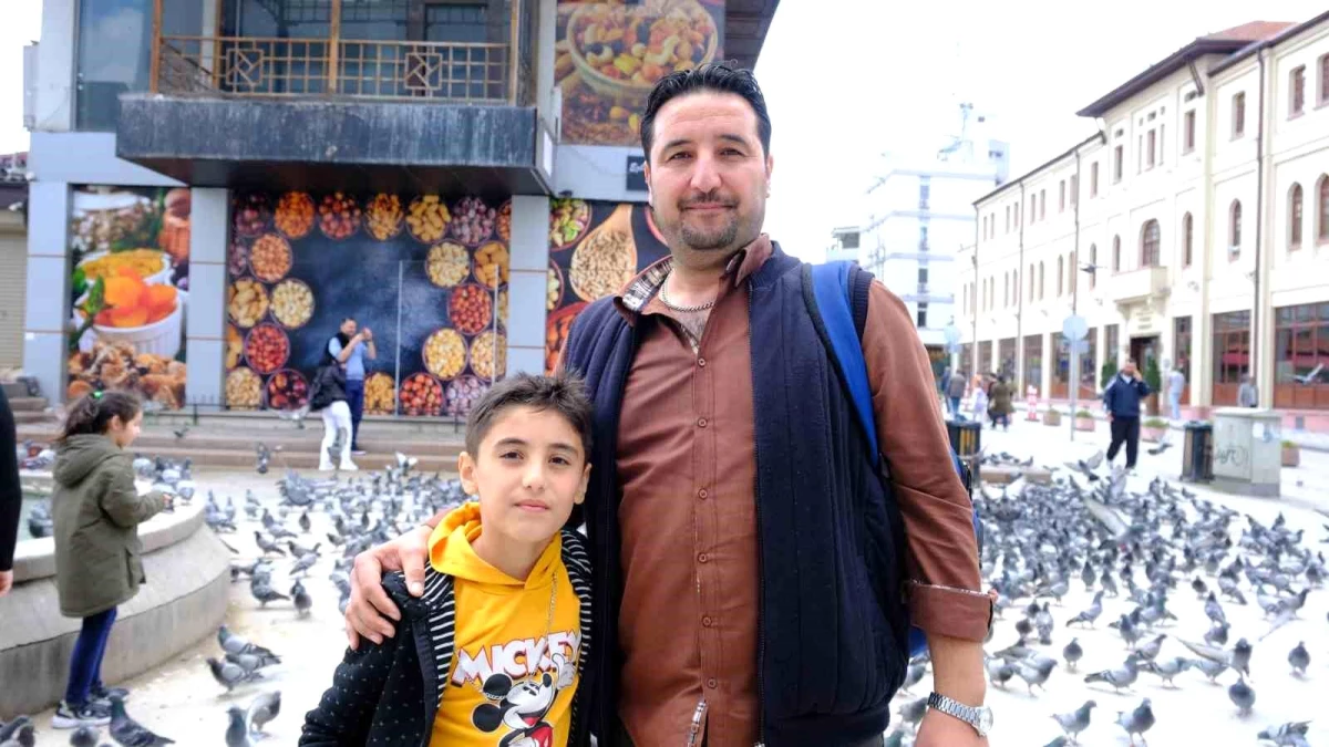 Eskişehir'e gezmeye gelen baba ve oğul sokaktaki güvercinleri besledi